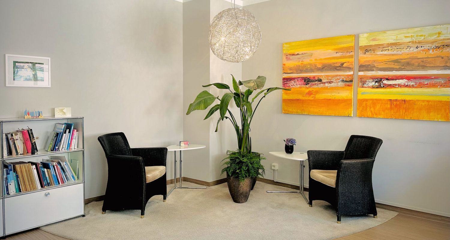 Wartebereich mit zwei Sesseln, Bücherregal in einem rot-gelben abstrakten Gemälde